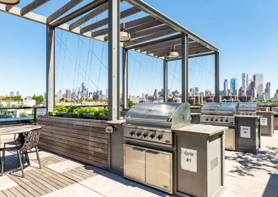 Rooftop lounge area with cabana, seating area, and 3 outdoors grill and a beautiful city view.