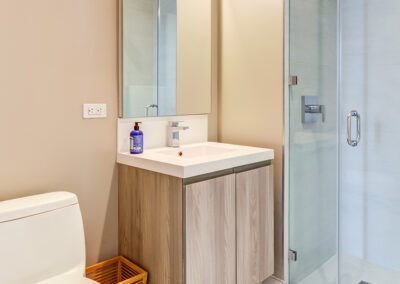 Bathroom with a sink, toilet, trashcan, and standup shower at 363 Bond Street apartments.