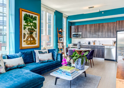 Brooklyn luxury apartments furnished indoor living room and kitchen space with blue walls on hardwood floors.