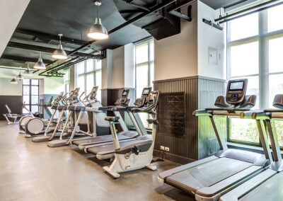Brooklyn luxury apartments spacious indoor fitness center with various workout equipment facing huge windows