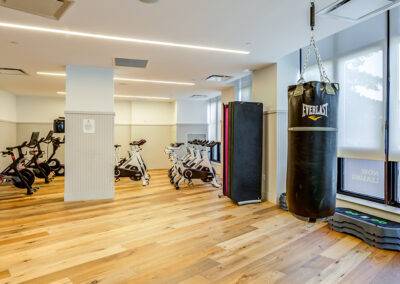 Indoor yoga studio with boxing and workout equipment on hardwood floors at 363 Bond Street apartments.